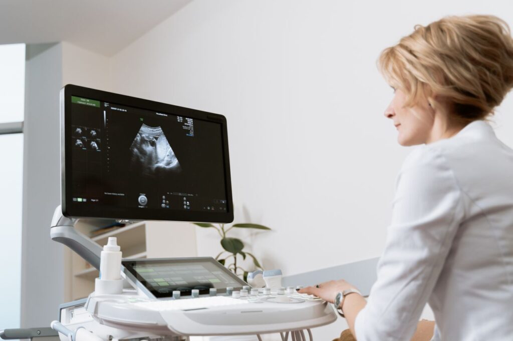Sonographer reviewing an ultrasound image on the scanner monitor during a renal artery duplex exam